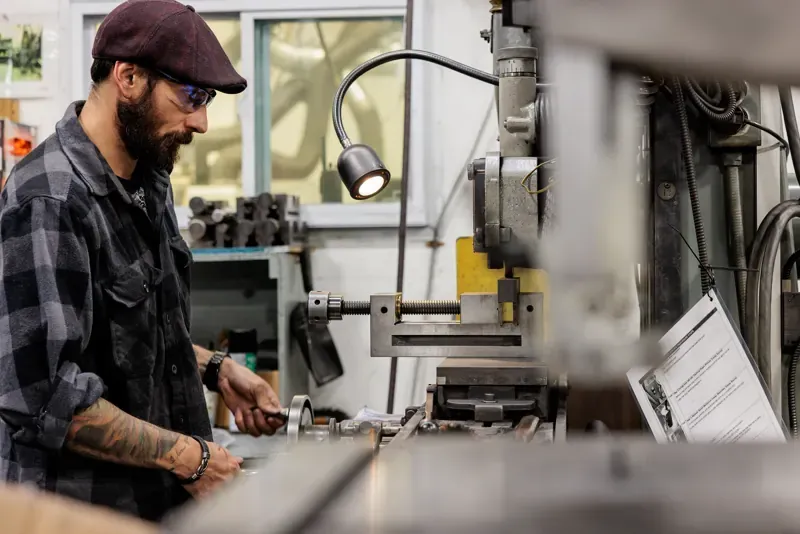 Machinist working at a milling machine on the FMI shop floor